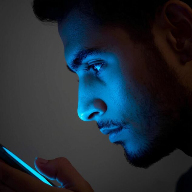 Pessoa usando celular recebendo luz azul nos olhos, a pessoa deve ter aparencia de brasileiro